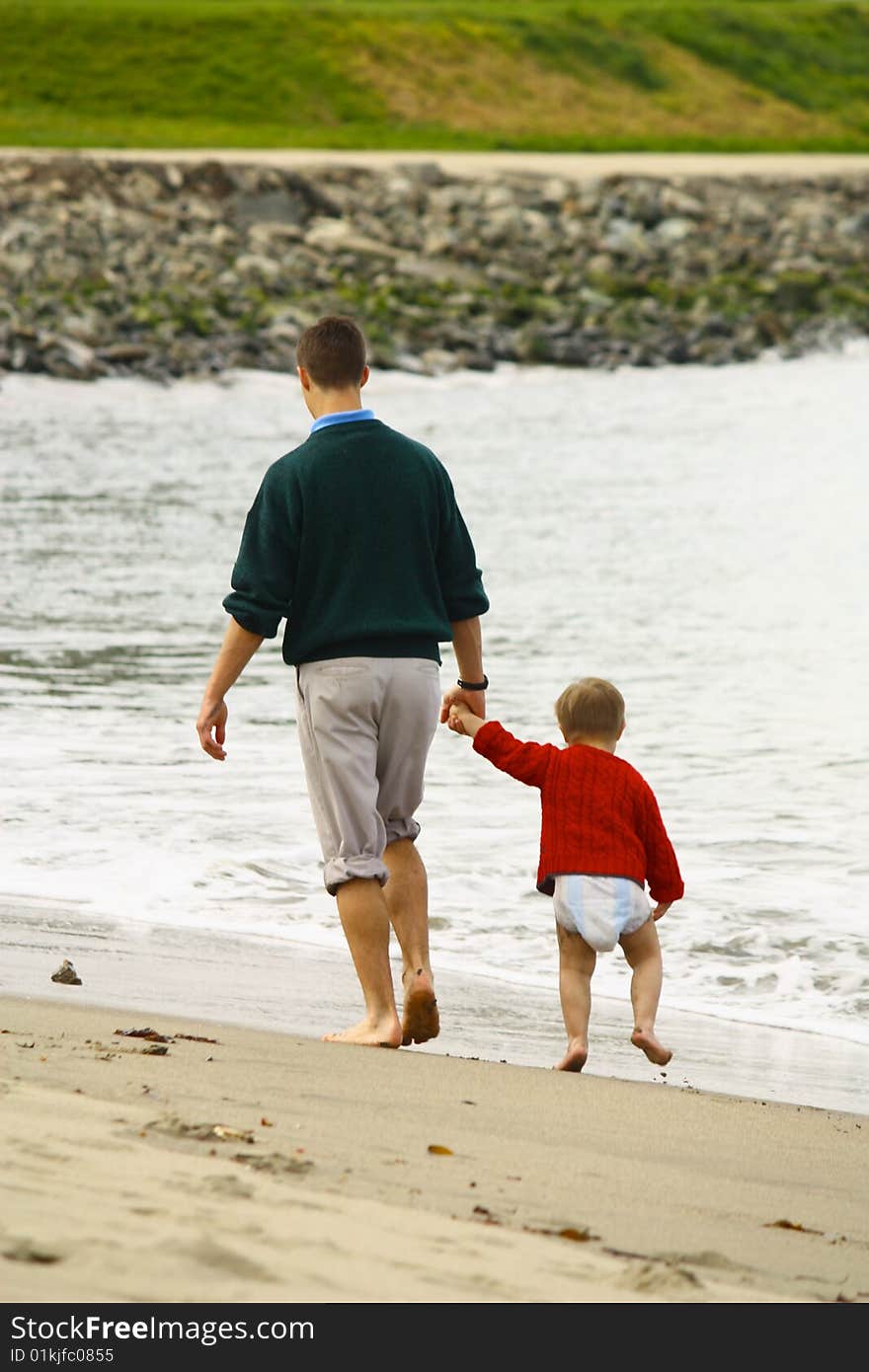 Big brother walking little brother on beach