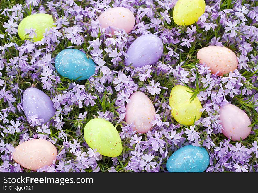 A colorful collection of Easter Eggs scattered on a background of fresh purple Phlox blooms. A colorful collection of Easter Eggs scattered on a background of fresh purple Phlox blooms