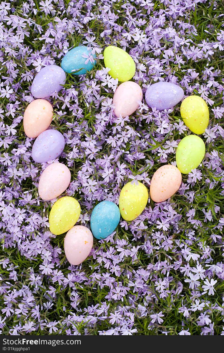 Pastel colored Easter Eggs in a heart shape on a background of fresh purple Phlox blooms. Pastel colored Easter Eggs in a heart shape on a background of fresh purple Phlox blooms