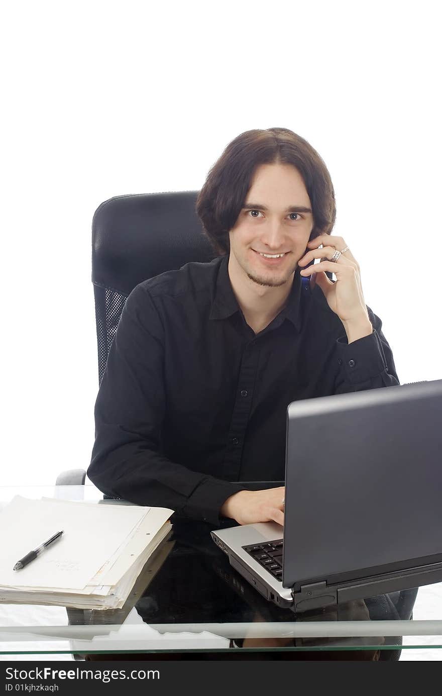 A young man working in his office with notebook and phone, isolated on white. A young man working in his office with notebook and phone, isolated on white