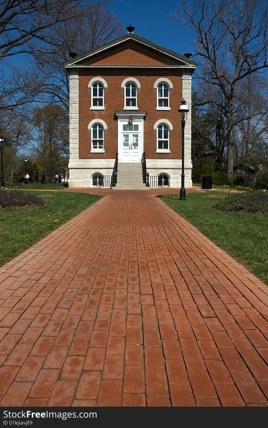 Two-story brick and stone home and red brick walkway. Two-story brick and stone home and red brick walkway.