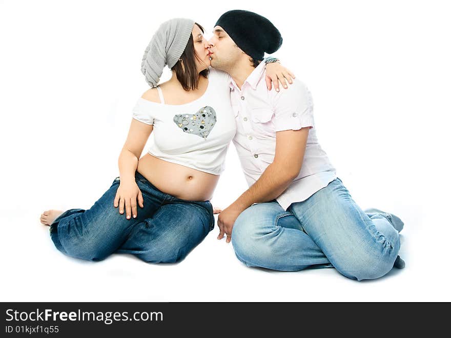 Young pregnant woman and her husband kissing