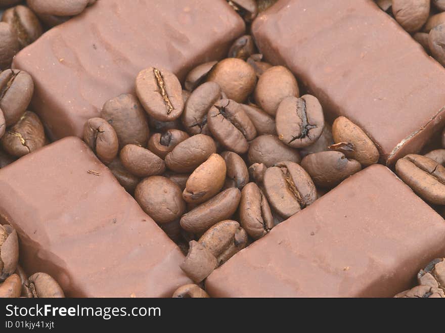 Chocolate on the coffee beans background. Chocolate on the coffee beans background