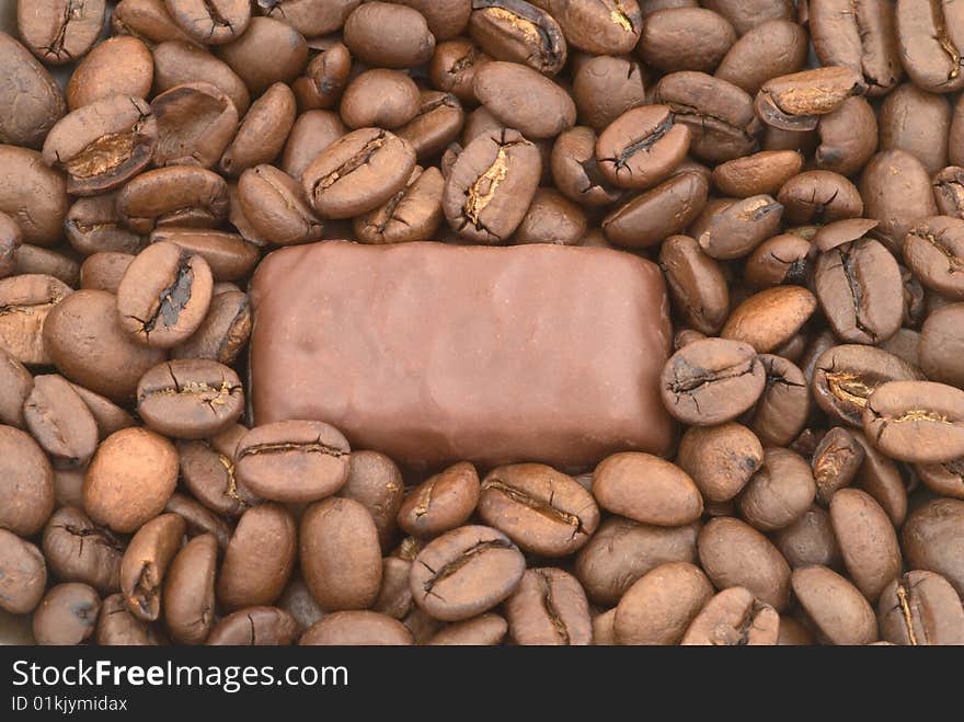 Dark chocolate on the coffee beans background