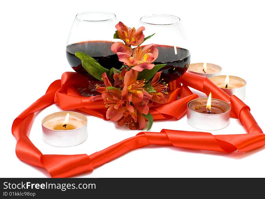 Two glasses of red wine combined with ribbon and flower. Two glasses of red wine combined with ribbon and flower.