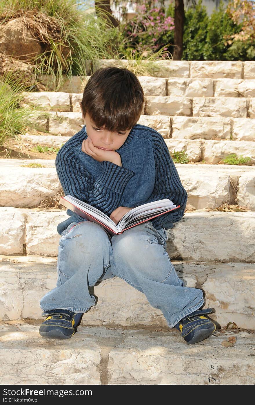 The boy reading the book in park