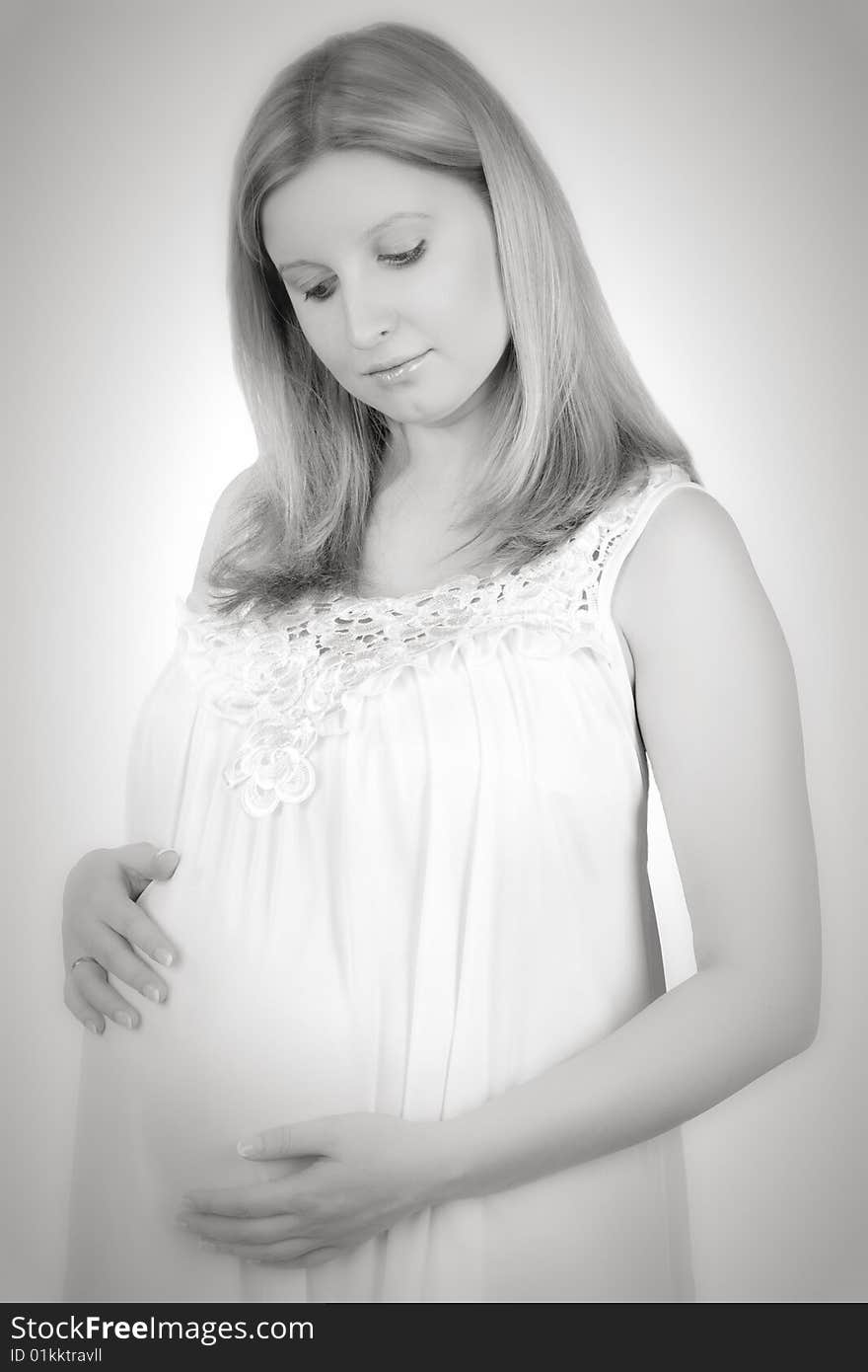 Studio portrait of the pregnant woman in pink on a white background