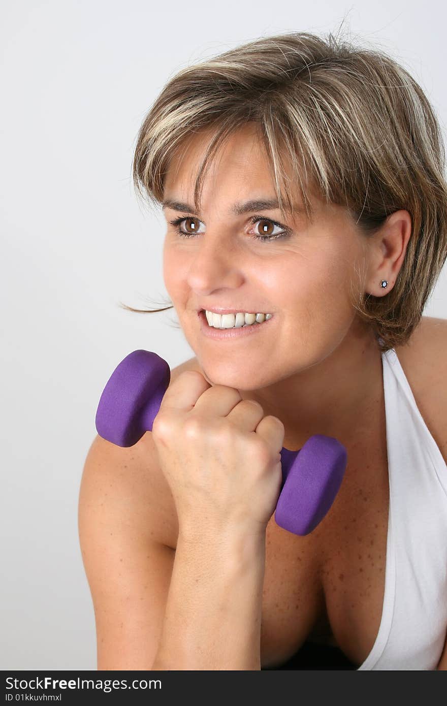 Friendly mature female exercising with small weights. Friendly mature female exercising with small weights