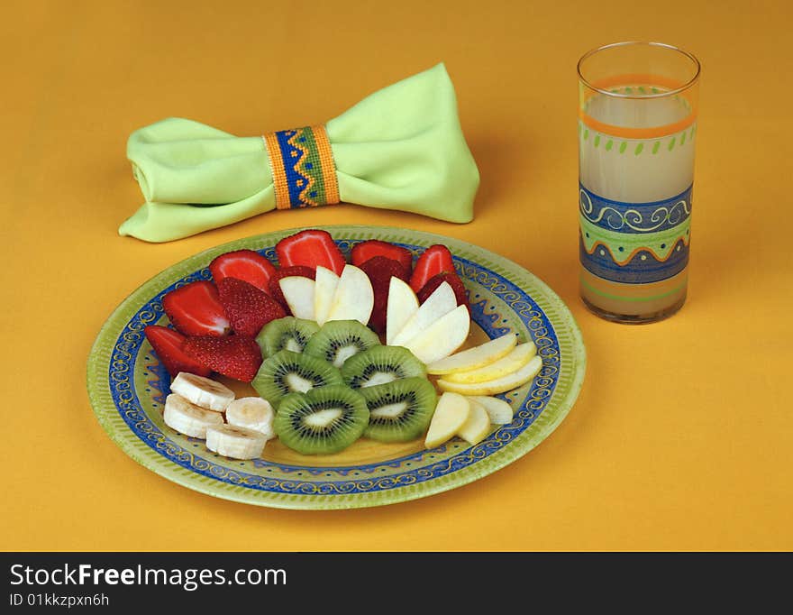 Useful breakfast - fruit salad and a glass of juice of a grapefruit, a decorative napkin