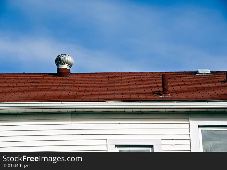 A view of the roof top with a vent on an urban home.