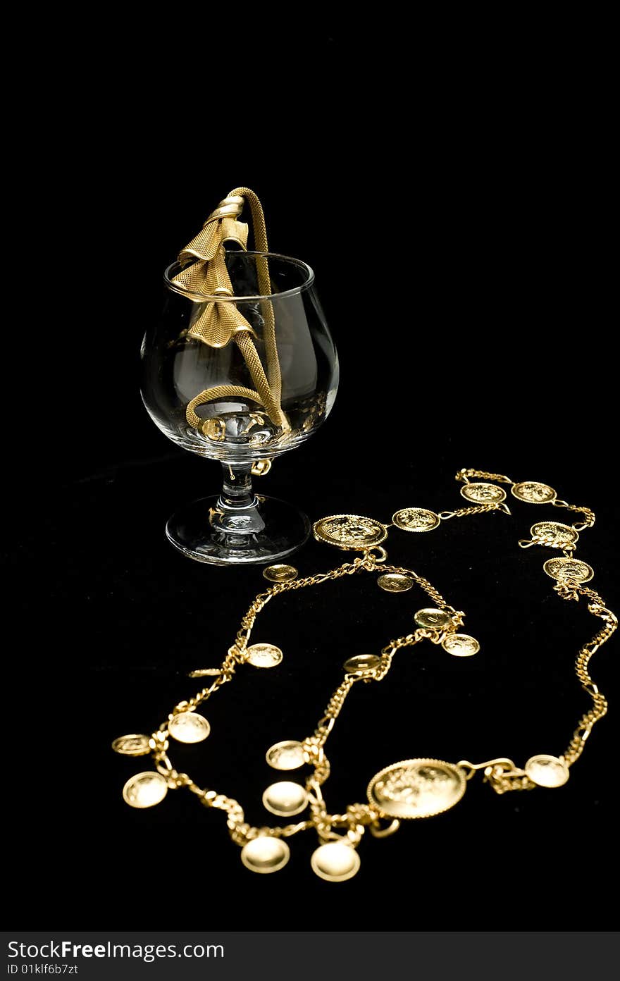 Costume jewelery placed on a glass isolated on black background