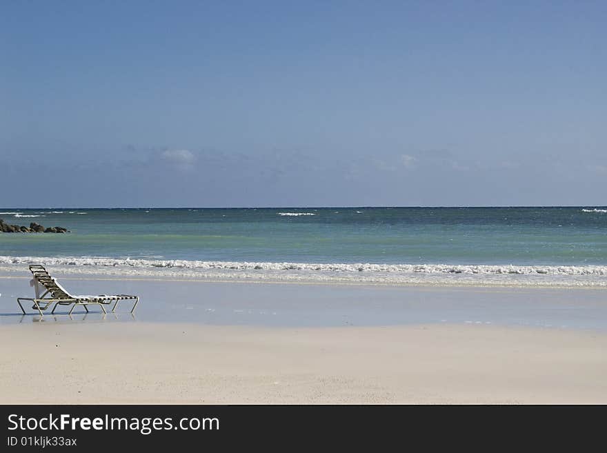 Lone beach chair on a Caribbean beach in Freeport Grand Bahama Island