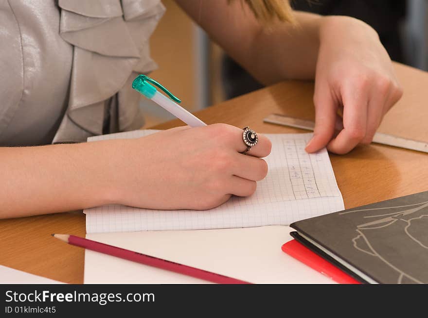 Black ring on a hand of the young woman working behind a desk. Black ring on a hand of the young woman working behind a desk.