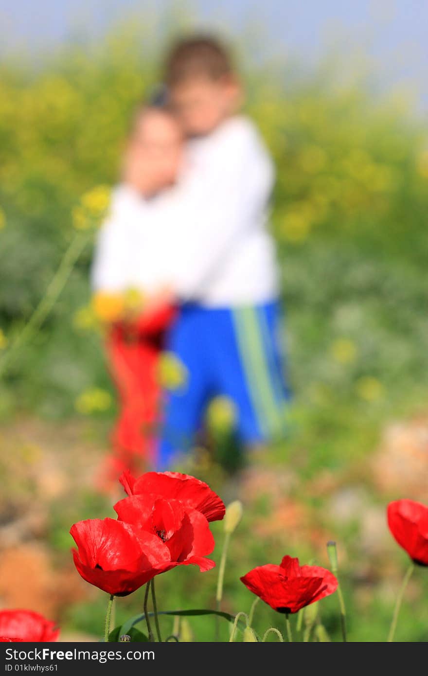 Kids on poppy field in summer time