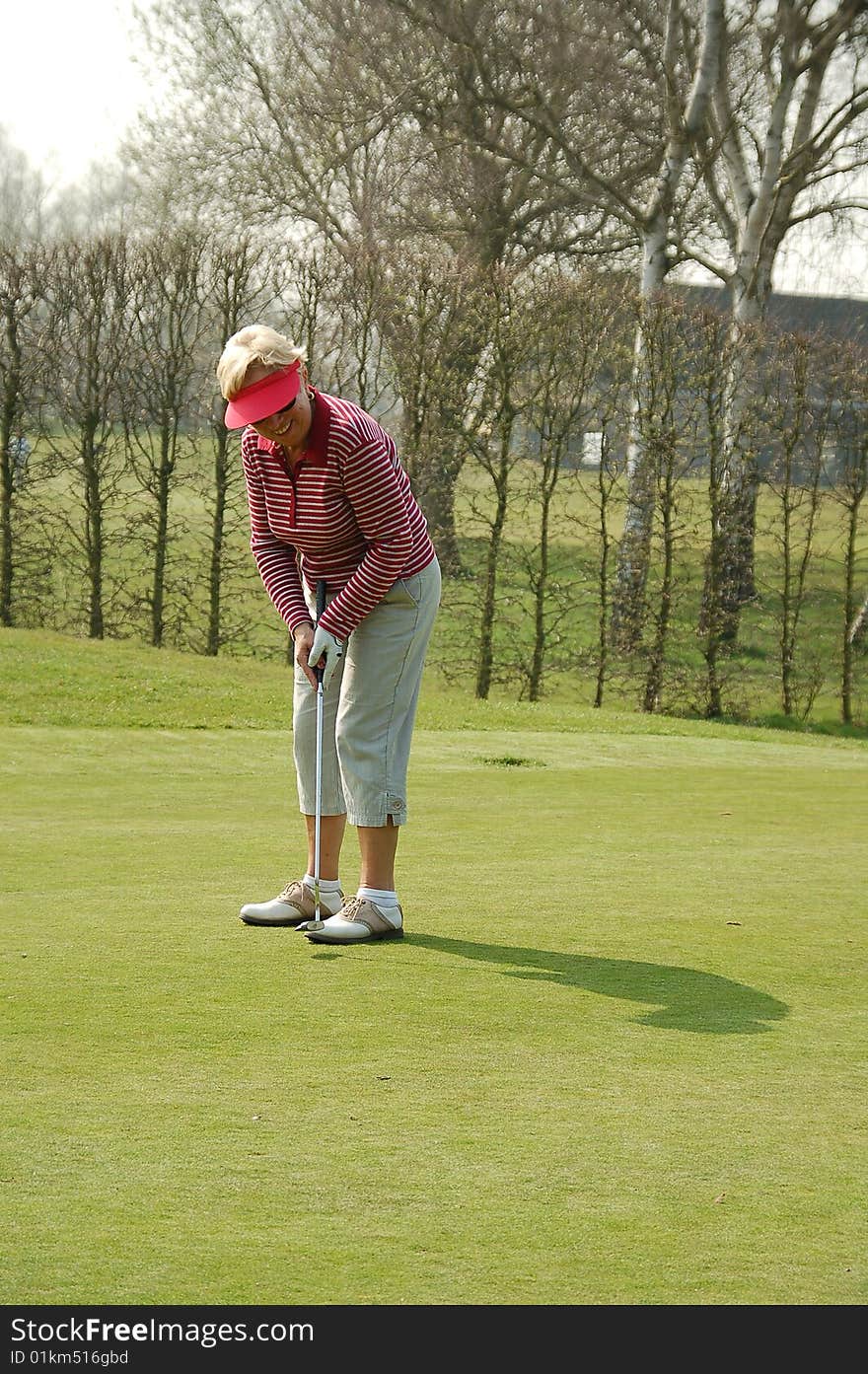 Female golfer putting on the green