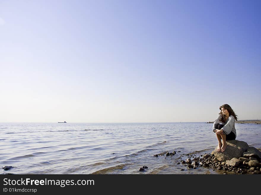 The image of a beautiful brunette girl on the beach