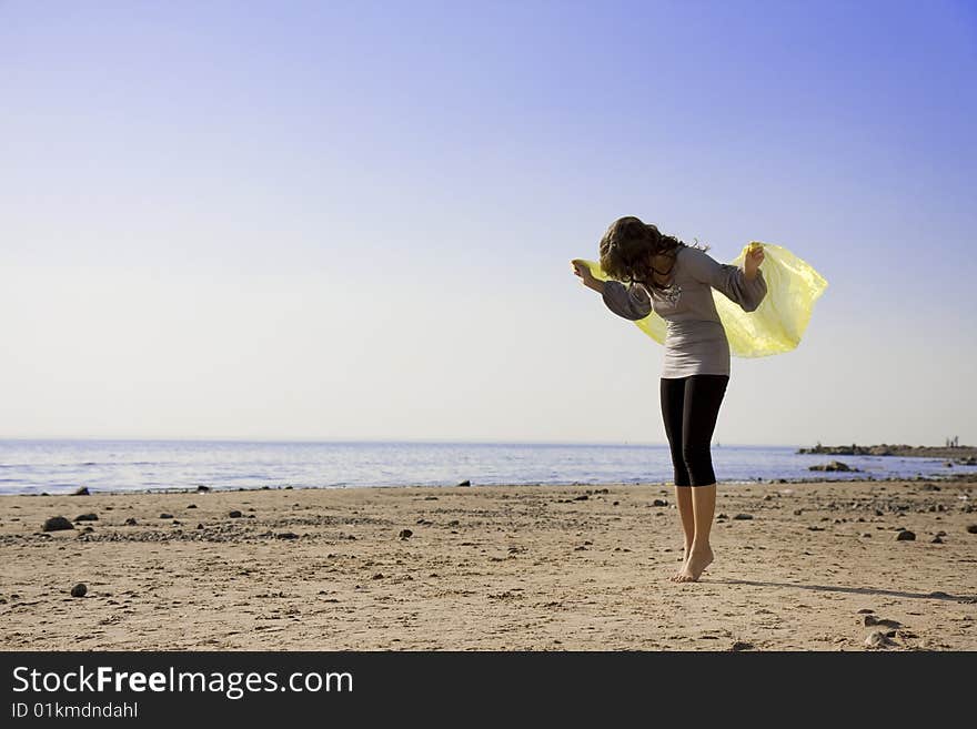 The image of a beautiful brunette girl on the beach