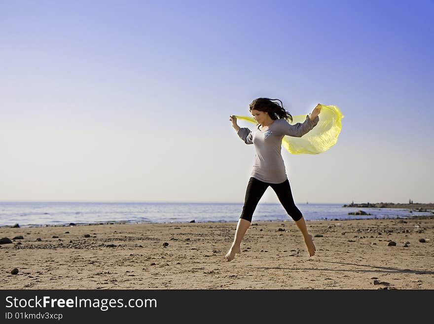 The image of a beautiful brunette girl on the beach