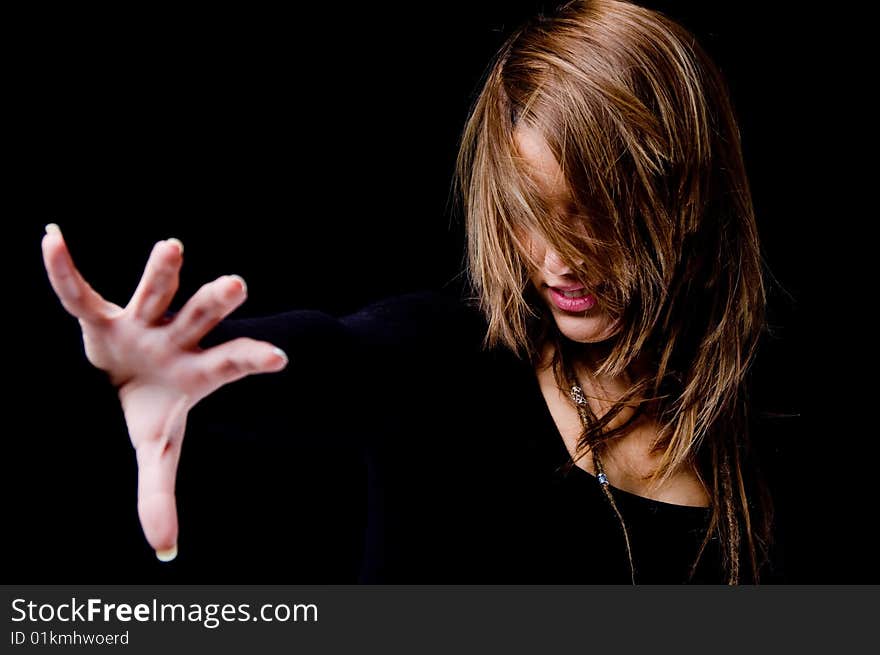 Portrait of smiling woman hiding her face with hair and showing hand gesture