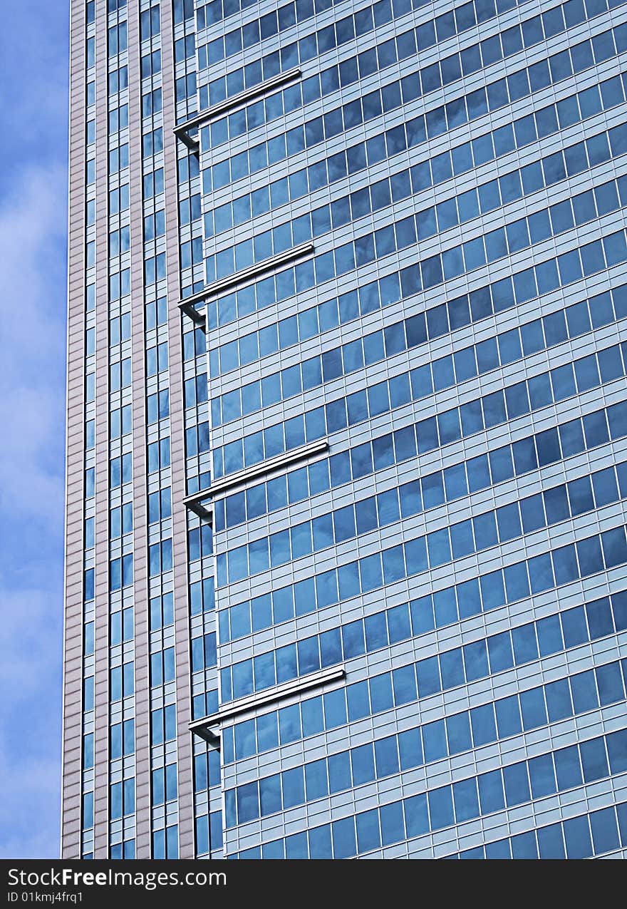 A fragment of city skyscraper, photo was taken in Warsaw. the buliding window's are reflecting blue sky. A fragment of city skyscraper, photo was taken in Warsaw. the buliding window's are reflecting blue sky