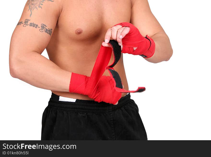 Topless boxer adult man wrapping his hands in red boxing tape before a fight. Topless boxer adult man wrapping his hands in red boxing tape before a fight