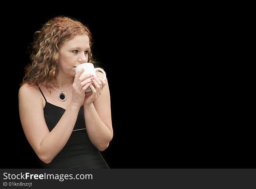 Attractive redhead in a black dress drinking coffee with copyspace. Attractive redhead in a black dress drinking coffee with copyspace