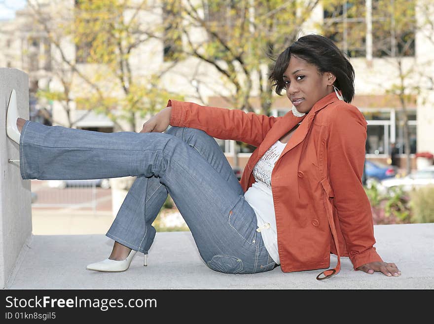 One attractive minority female model laying back on the stone ground and posing outdoors. One attractive minority female model laying back on the stone ground and posing outdoors