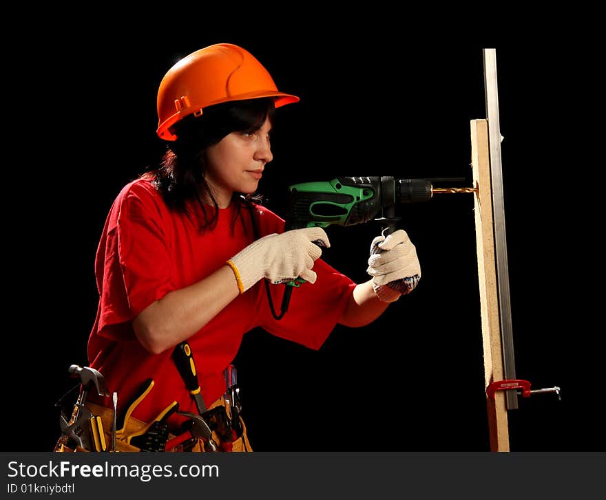 Young woman with work tools and drill, isolated on black