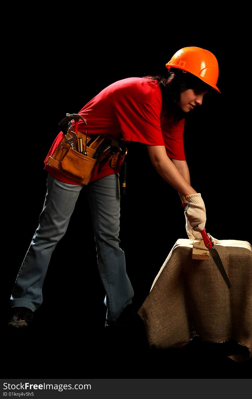 Young woman with work tools and hand saw, isolated on black