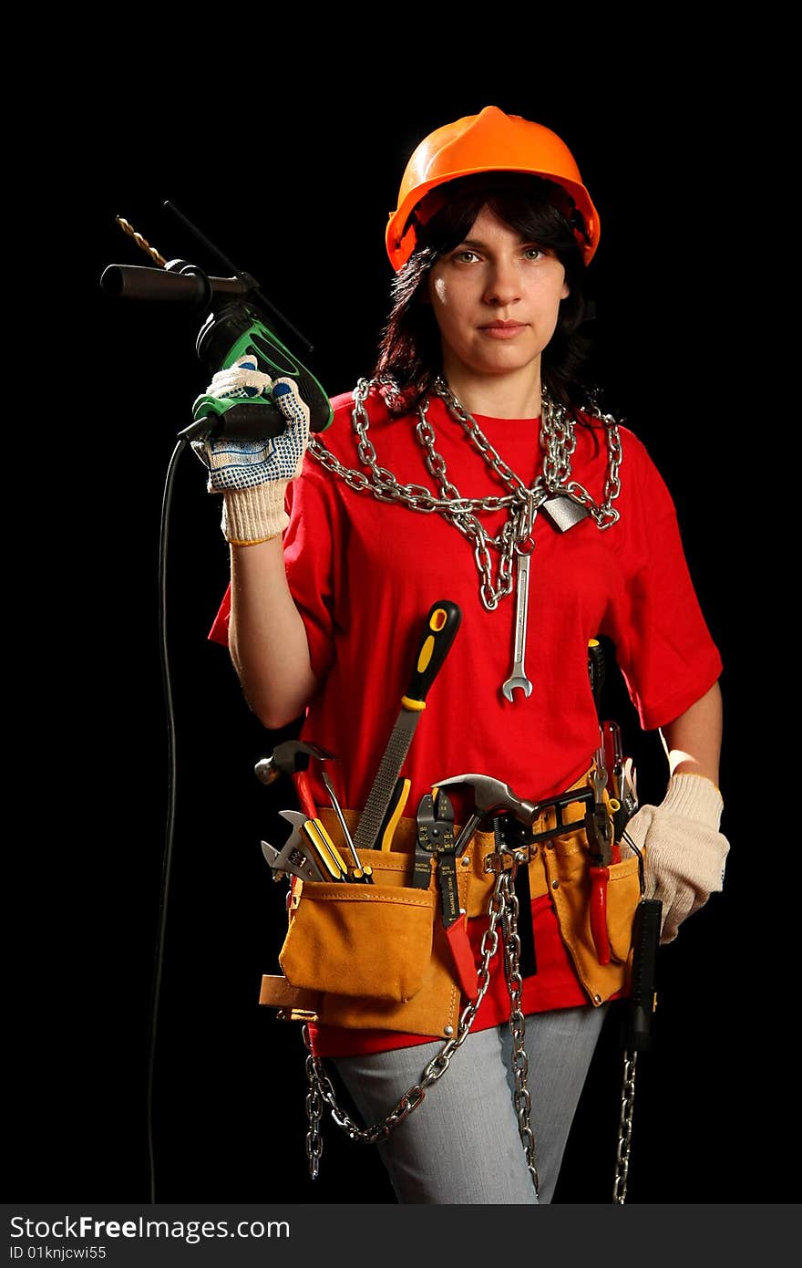 Young woman with work tools and drill, isolated on black