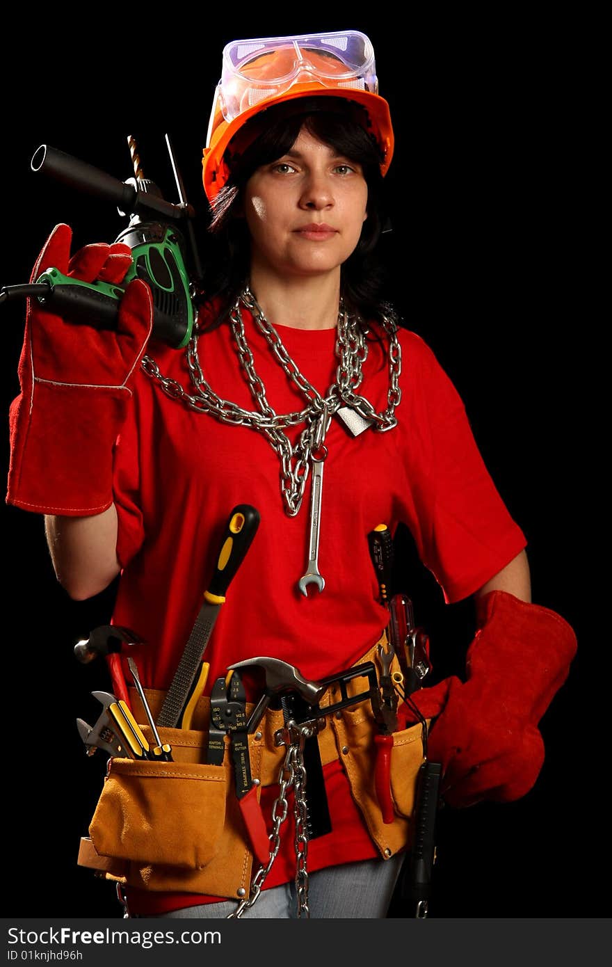 Young woman with work tools and drill, isolated on black