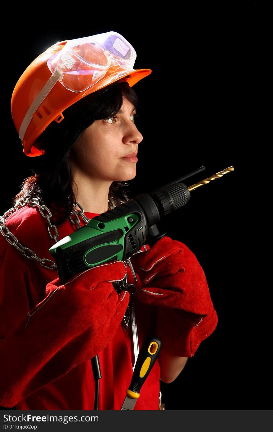 Young woman with drill, isolated on black