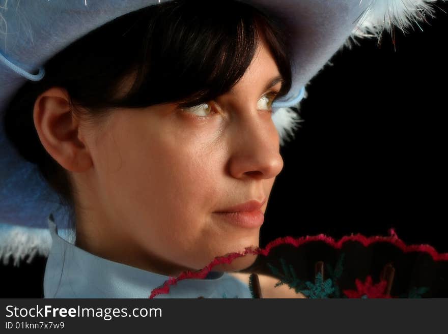 Brunette girl with cowboy hat and spanish fan