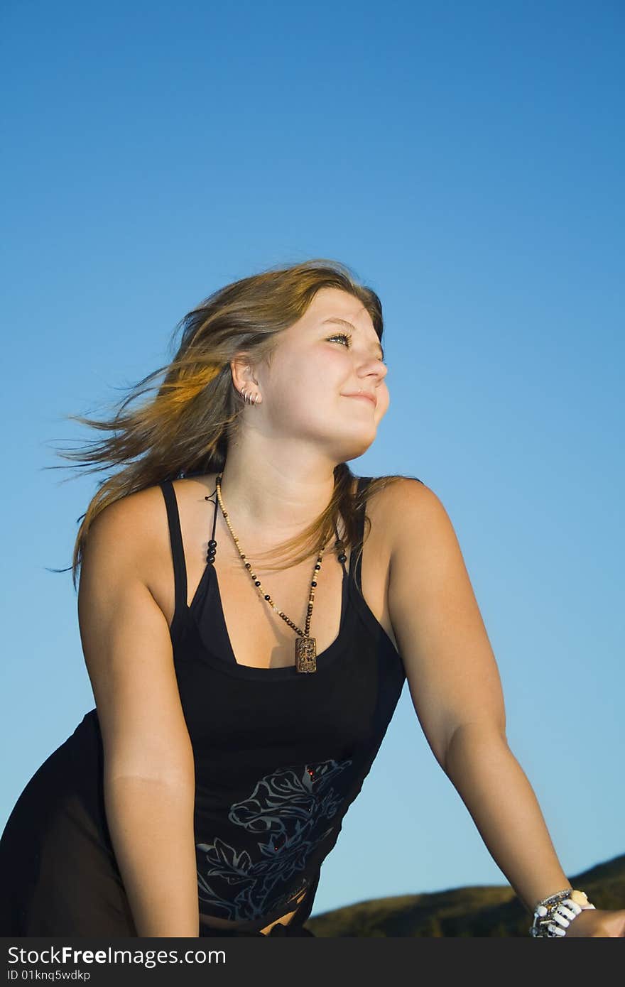 Beautiful young woman enjoying sunshine and breeze