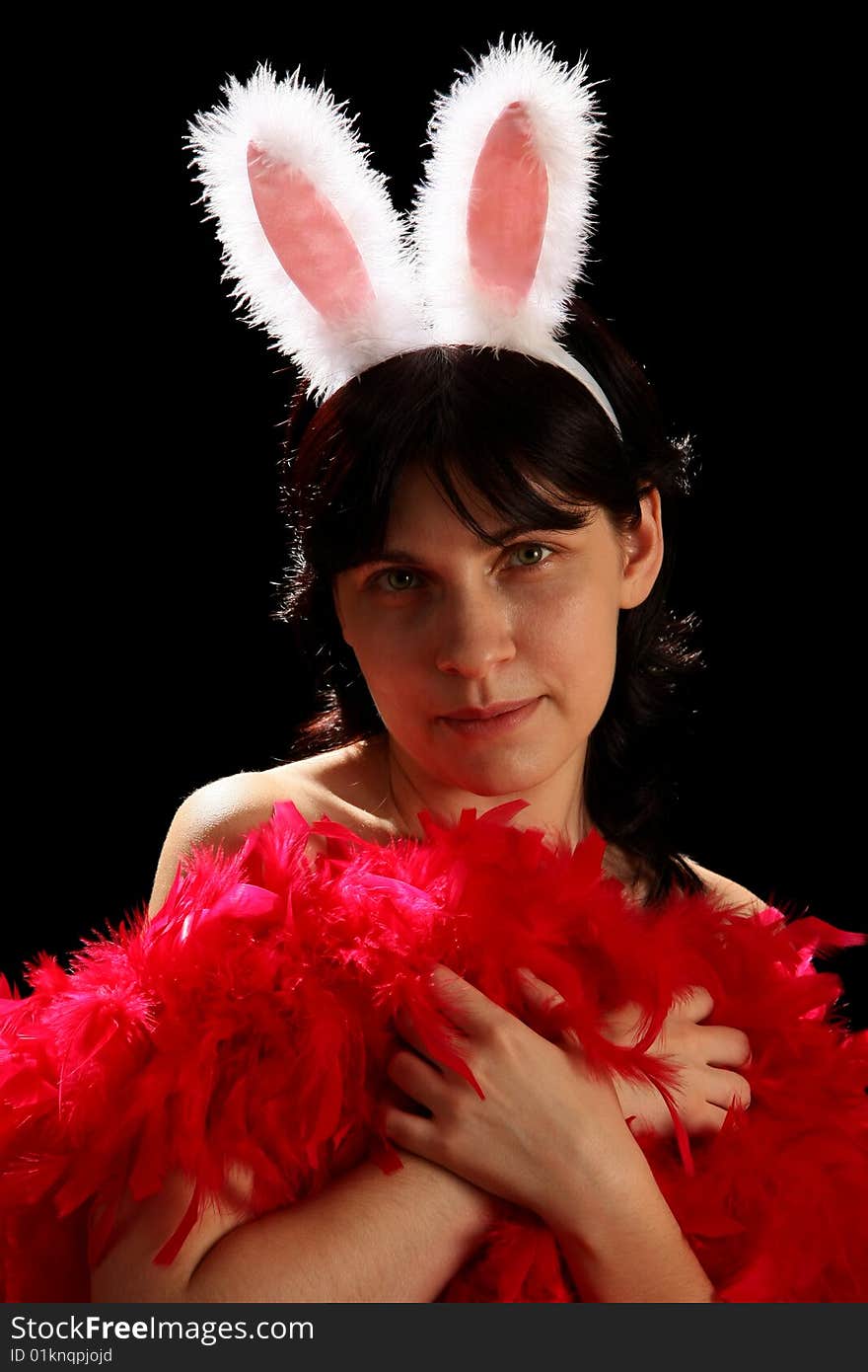 Young woman with fun bunny ears and red feathers, isolated on black