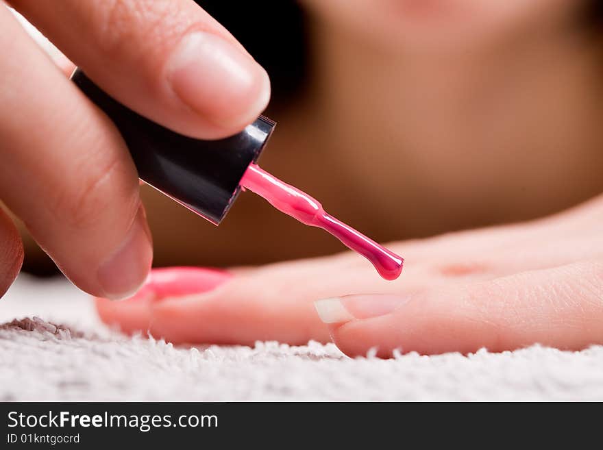 Woman applying red nail polish