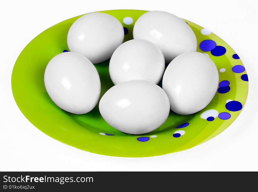 Six eggs on green plate isolated on white. Six eggs on green plate isolated on white