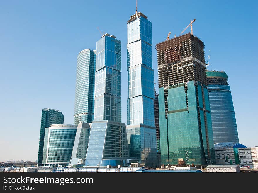 Sky-scrapers construction in Moscow, Russia Cranes and buildings over blue sky.