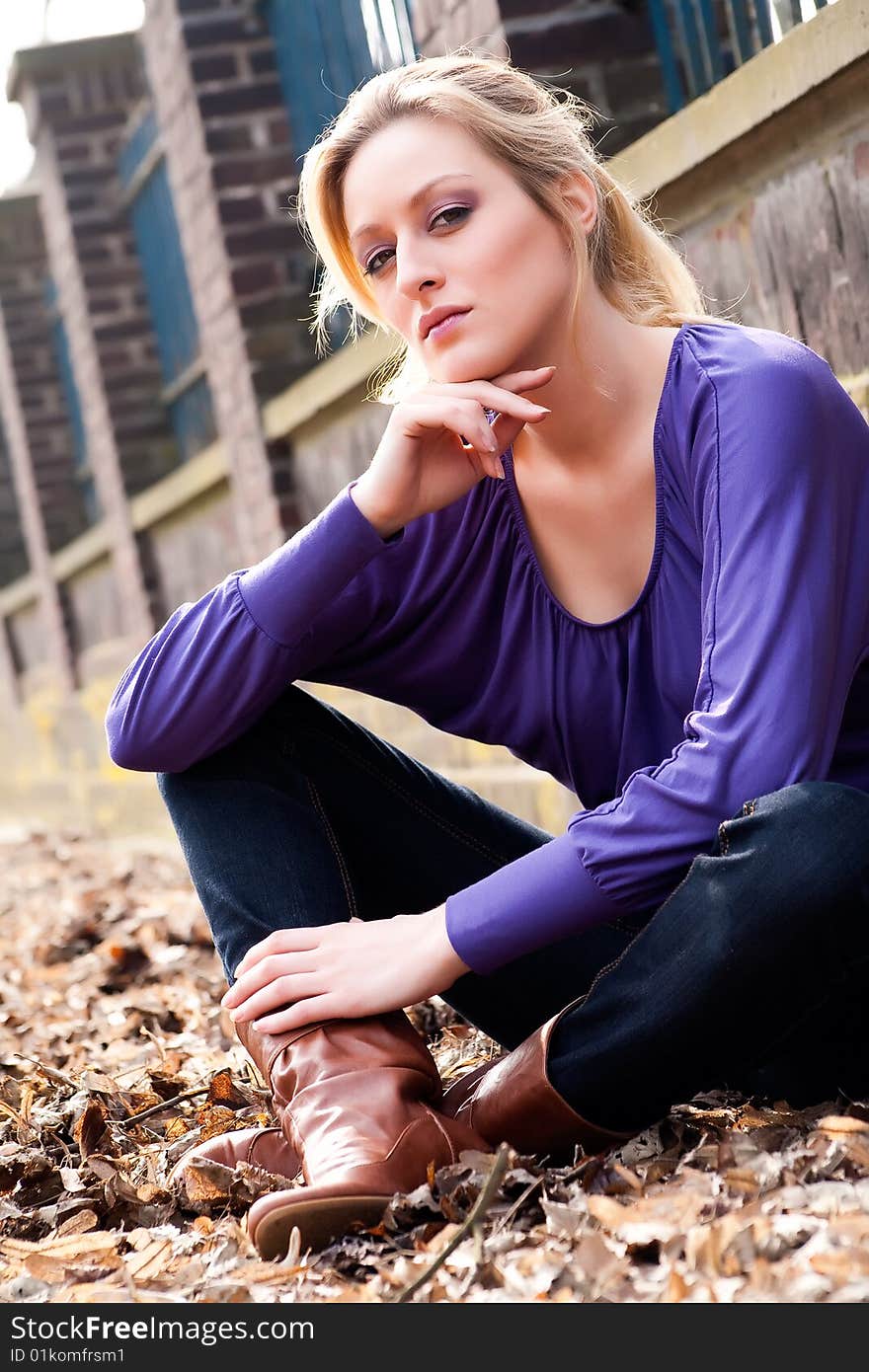 Young blond girl outside on a street posing against the wall. Young blond girl outside on a street posing against the wall