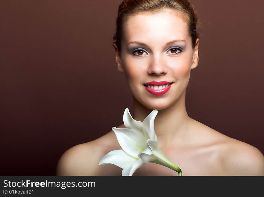 Beauty portrait of a young woman with a lily flower. Beauty portrait of a young woman with a lily flower