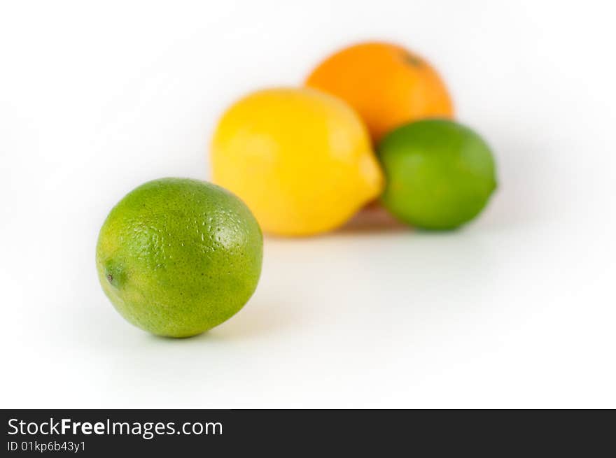 A close-up of a lime in front of a lemmon and an orange isolated on white. A close-up of a lime in front of a lemmon and an orange isolated on white.