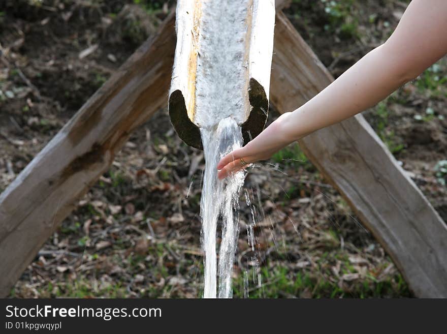 Little waterfall and a woman hand. Little waterfall and a woman hand