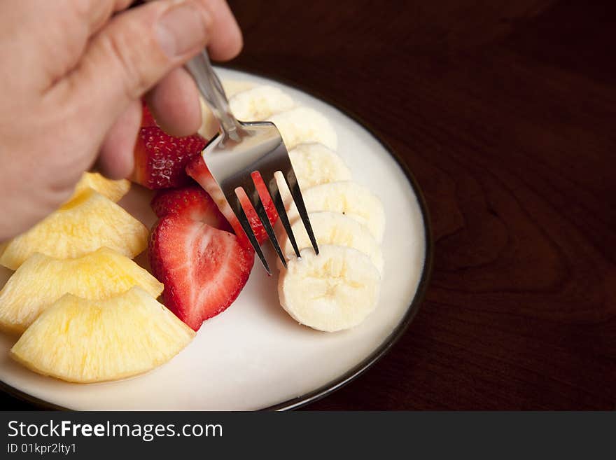 Picking up a slice of fresh banana on a fork. Picking up a slice of fresh banana on a fork