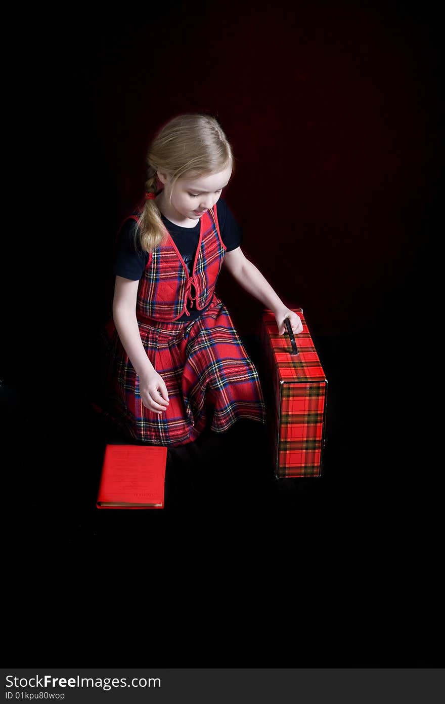 Serious schoolgirl with red book over dark. Serious schoolgirl with red book over dark