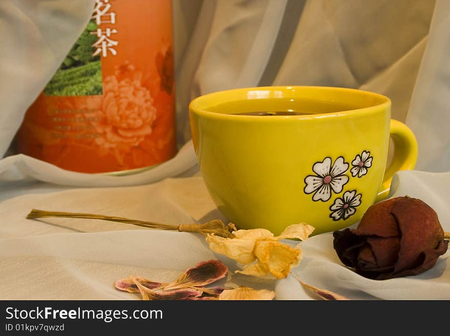 Still-life with yellow cup of green tea