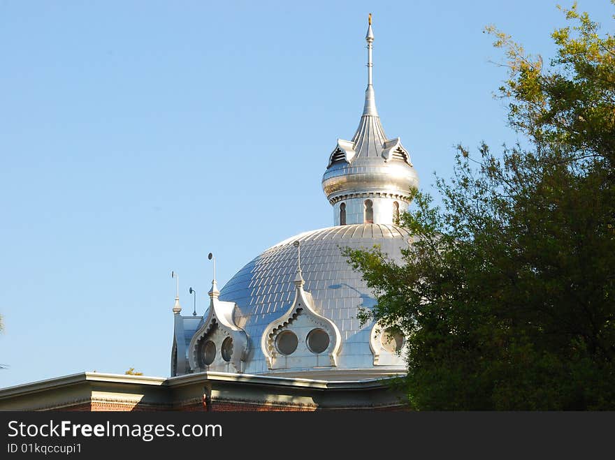 Towering minaret with against a blue sky at the University of Tampa hidden by an oak tree. Towering minaret with against a blue sky at the University of Tampa hidden by an oak tree.