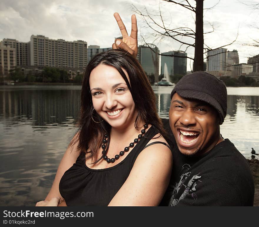 Man secretly placing bunny ears over his girlfriend. Man secretly placing bunny ears over his girlfriend