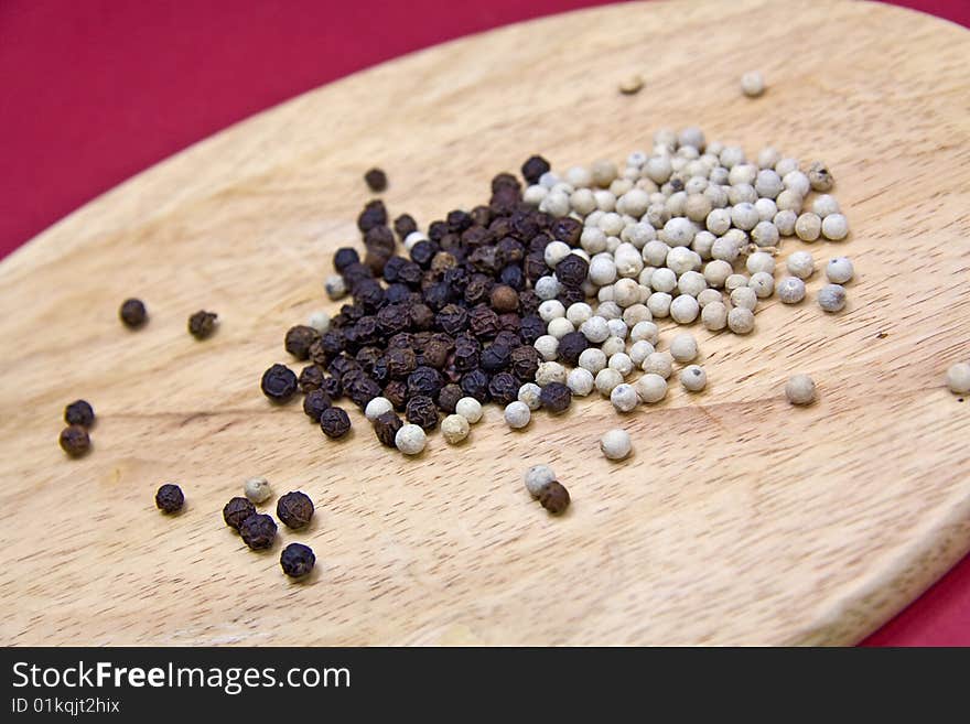 Mixed Pepper Grains On The Cutting Board With Mort