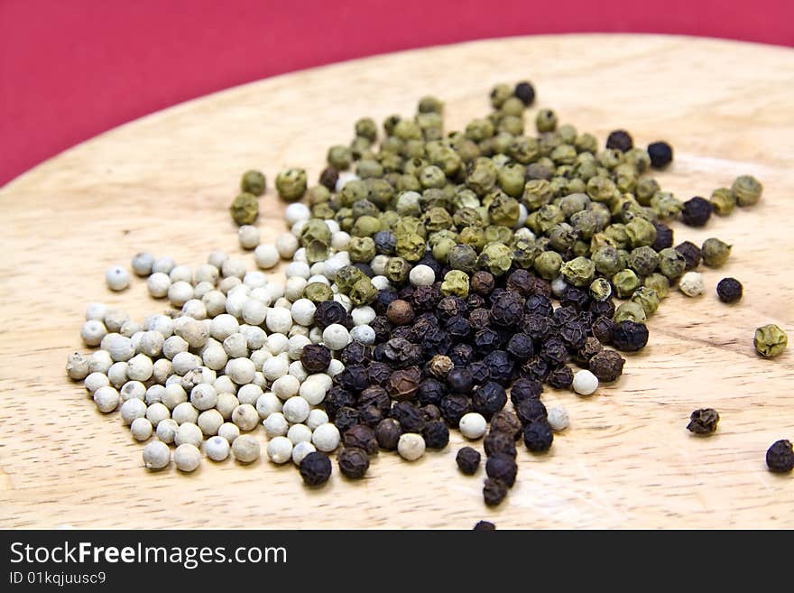 Mixed Pepper Grains On The Cutting Board With Mort