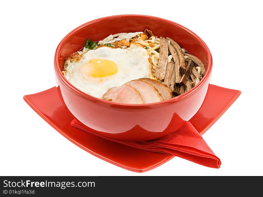 Soup with macaroni balyk omelet on red plate